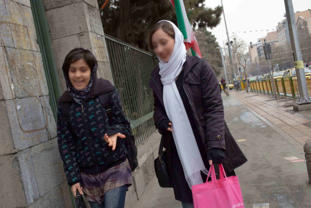 Two women walking past University of Tehran, Enghelab Street, Tehran, 2018 — from the Women in Public Space project