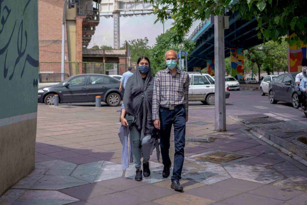 Elderly man beside a young woman at Hafez–Enghelab intersection, Tehran, 2022 — from the Women in Public Space project