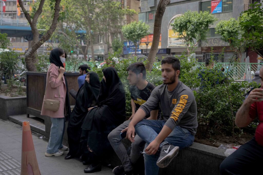 A family alongside young men, Hafez Street near Enghelab Street, Tehran, 2022 — from the Women in Public Space project